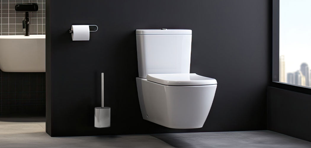 Chrome toilet brush and holder positioned beside modern white toilet in contemporary hotel bathroom with city view
