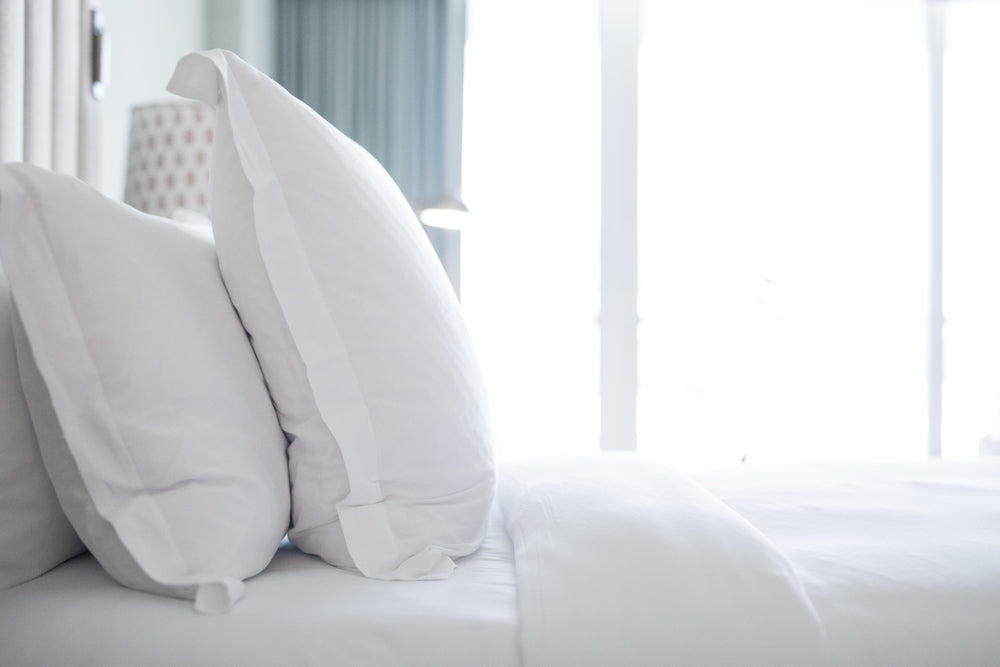 A luxurious collection of hotel bedding, including silky sheets, plush pillows, and lightweight duvets