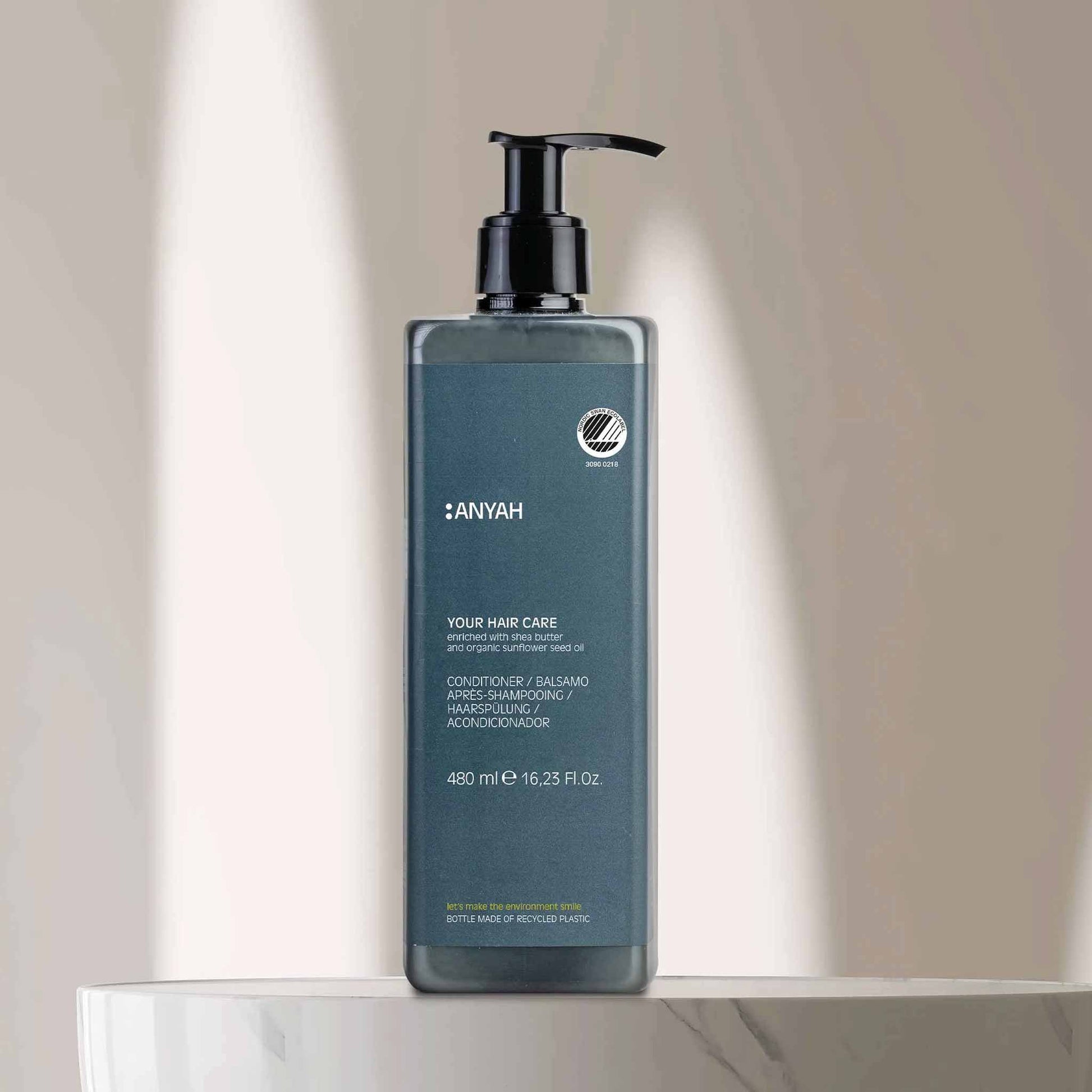 Anyah 480ml hair conditioner in non-refillable pump dispenser, enriched with shea butter and organic sunflower seed oil, displayed on marble bathroom surface