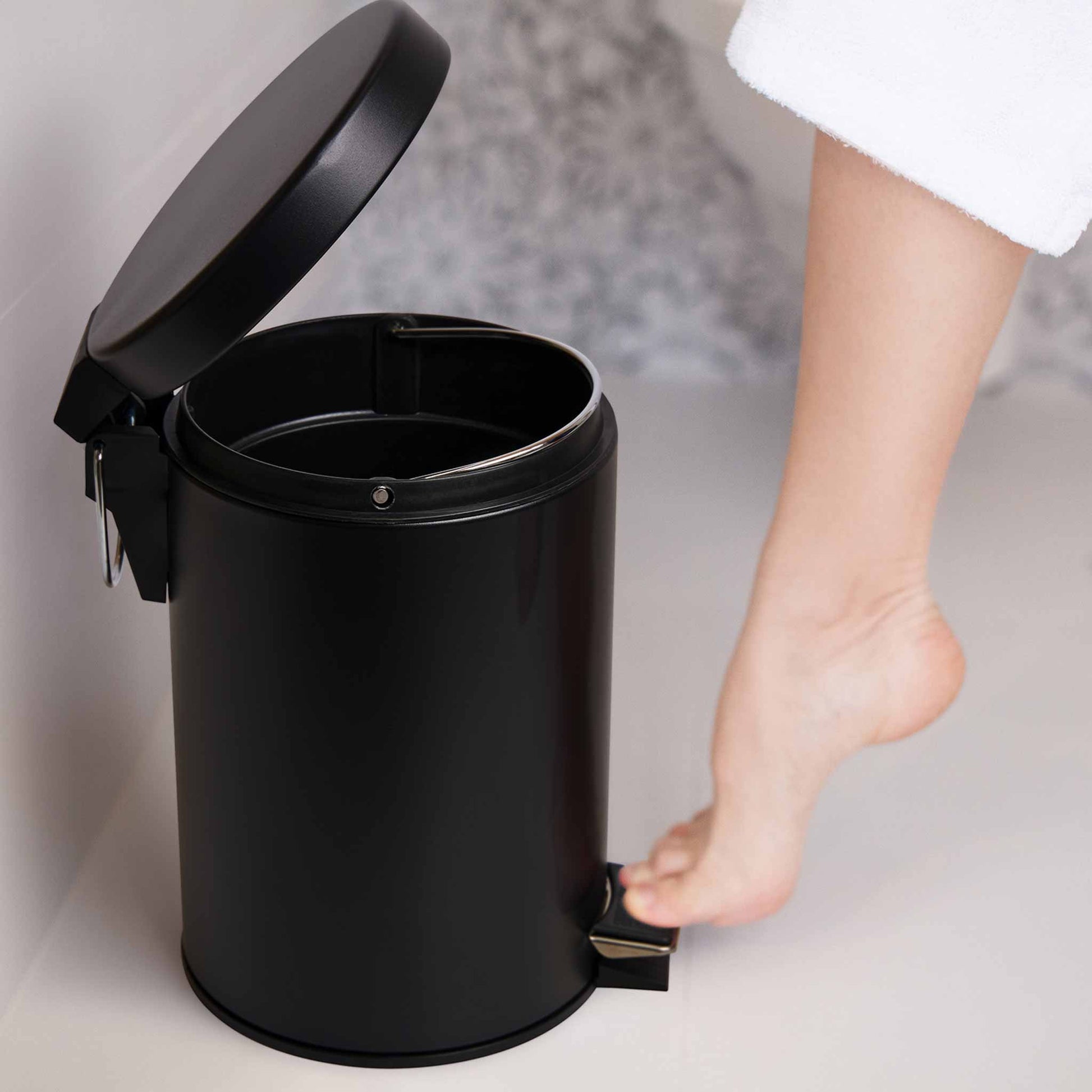 Corby Croft 3 litre black pedal bin in hotel bathroom being opened hands-free with foot pedal