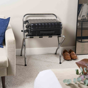 Corby Ashton chrome folding luggage rack with backrest holding suitcase on black nylon straps in hotel guest room