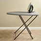 Corby Berkshire compact ironing board with light grey cover and iron placed on top, shown in hotel-style guest room with wooden flooring