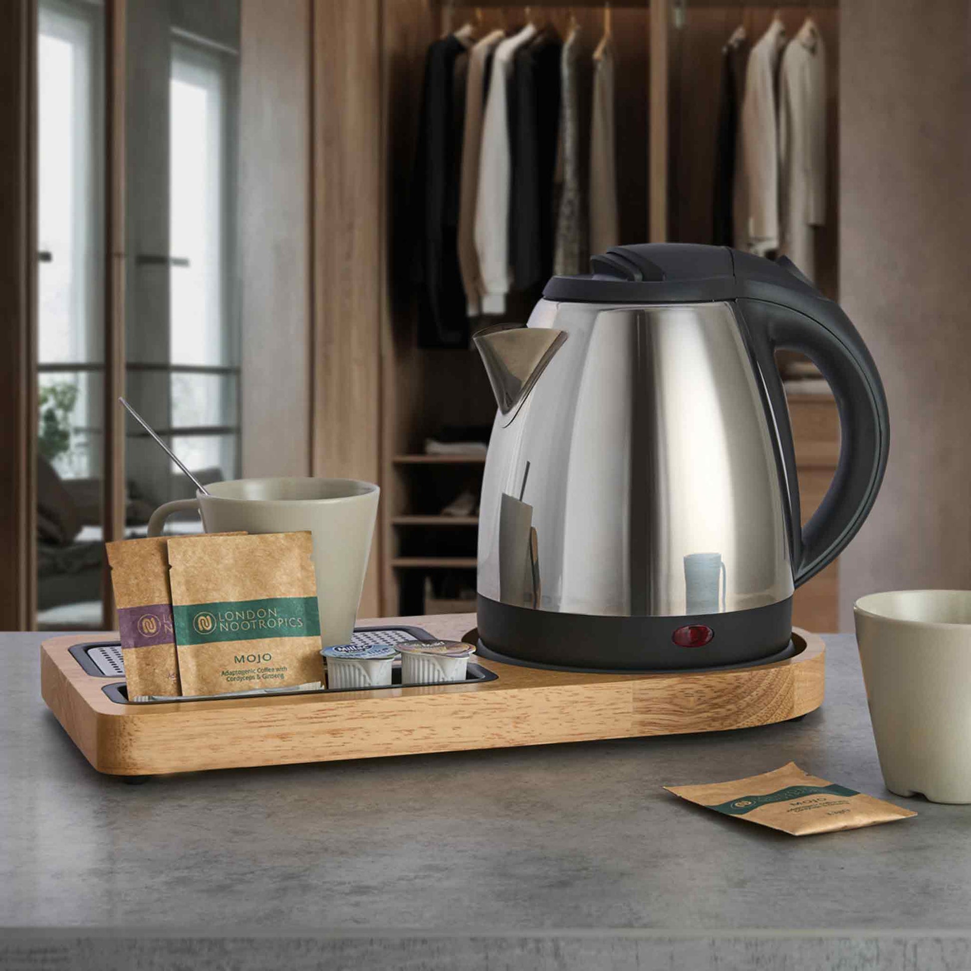 Corby Buckingham chrome hotel kettle on wooden hospitality tray with mugs, stirrer, and hot drink sachets in guest room setting