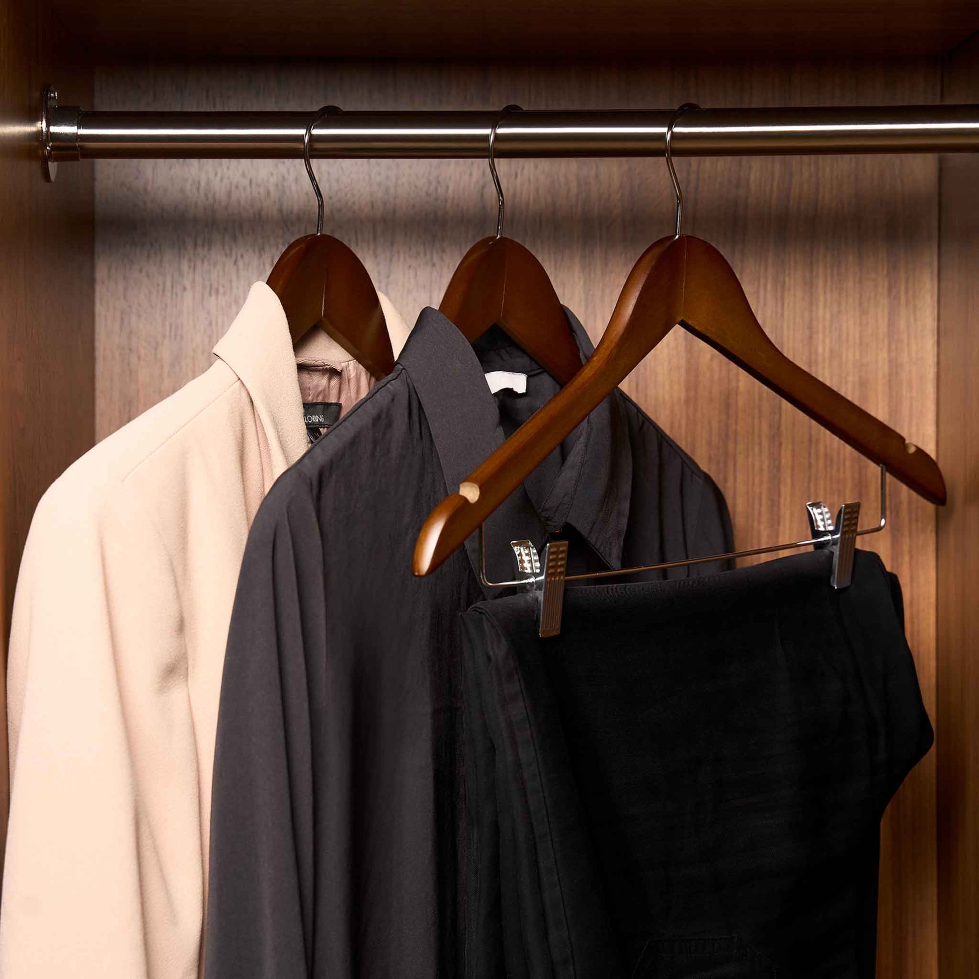 Corby Burlington dark wood guest hangers with clips holding jacket and trousers in hotel wardrobe