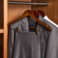 Corby Burlington dark wood skirt hangers with chrome hooks and clips holding suit and trousers in hotel wardrobe