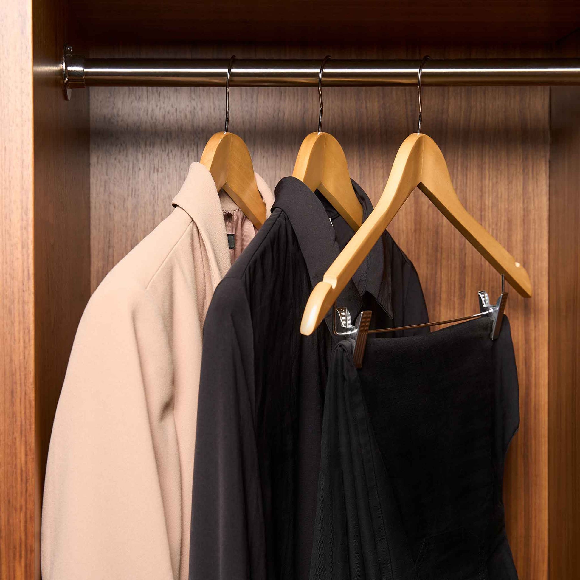 Corby Burlington light wood guest hangers with chrome hooks holding guest clothing in hotel wardrobe