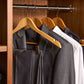 Corby Burlington light wood guest hangers with chrome clips holding suit and shirt in hotel wardrobe