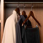 Corby Burlington dark wood security hangers with chrome clips and notches holding guest clothing on anti-theft rail in hotel wardrobe