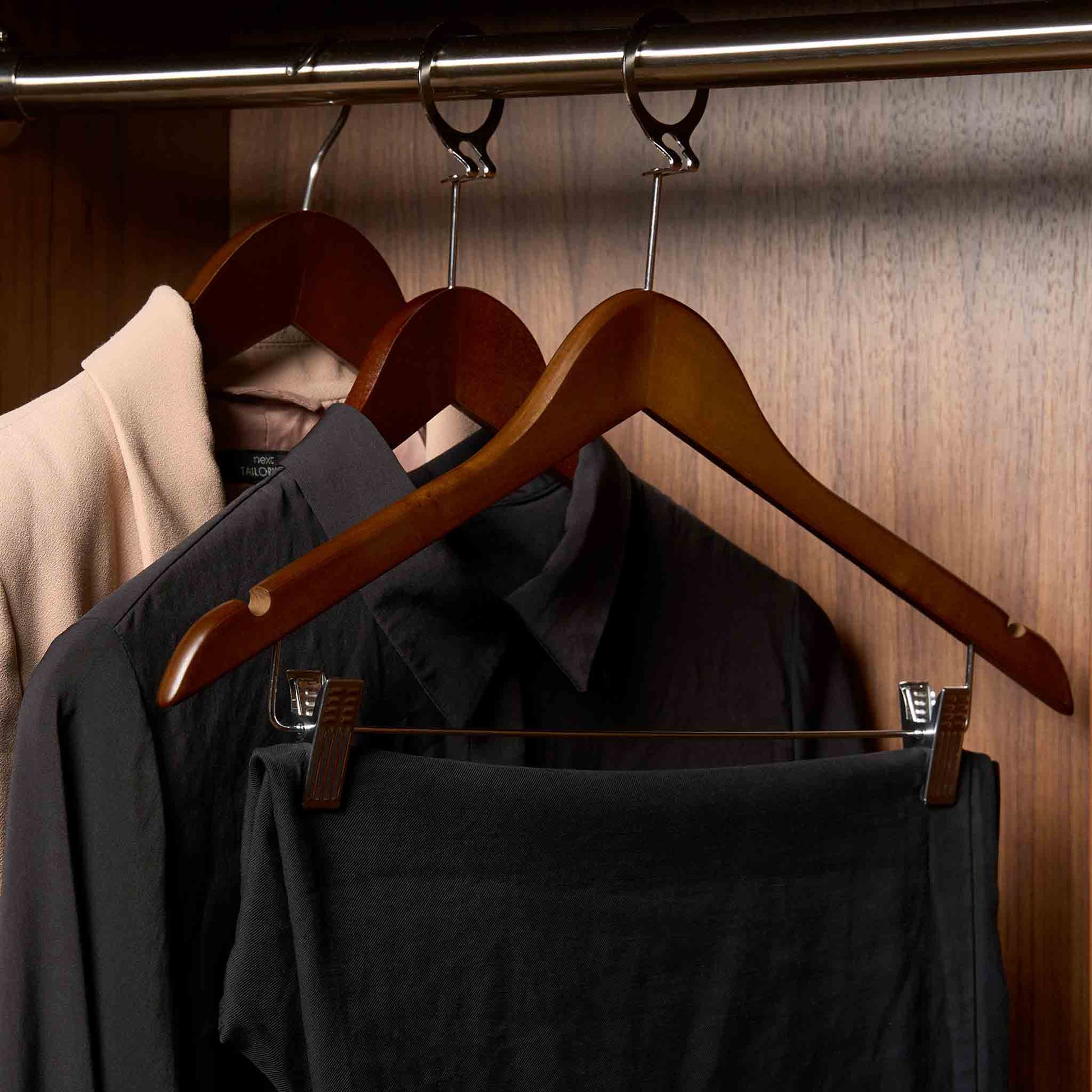 Corby Burlington dark wood security hanger with chrome clips holding trousers in hotel guest room wardrobe