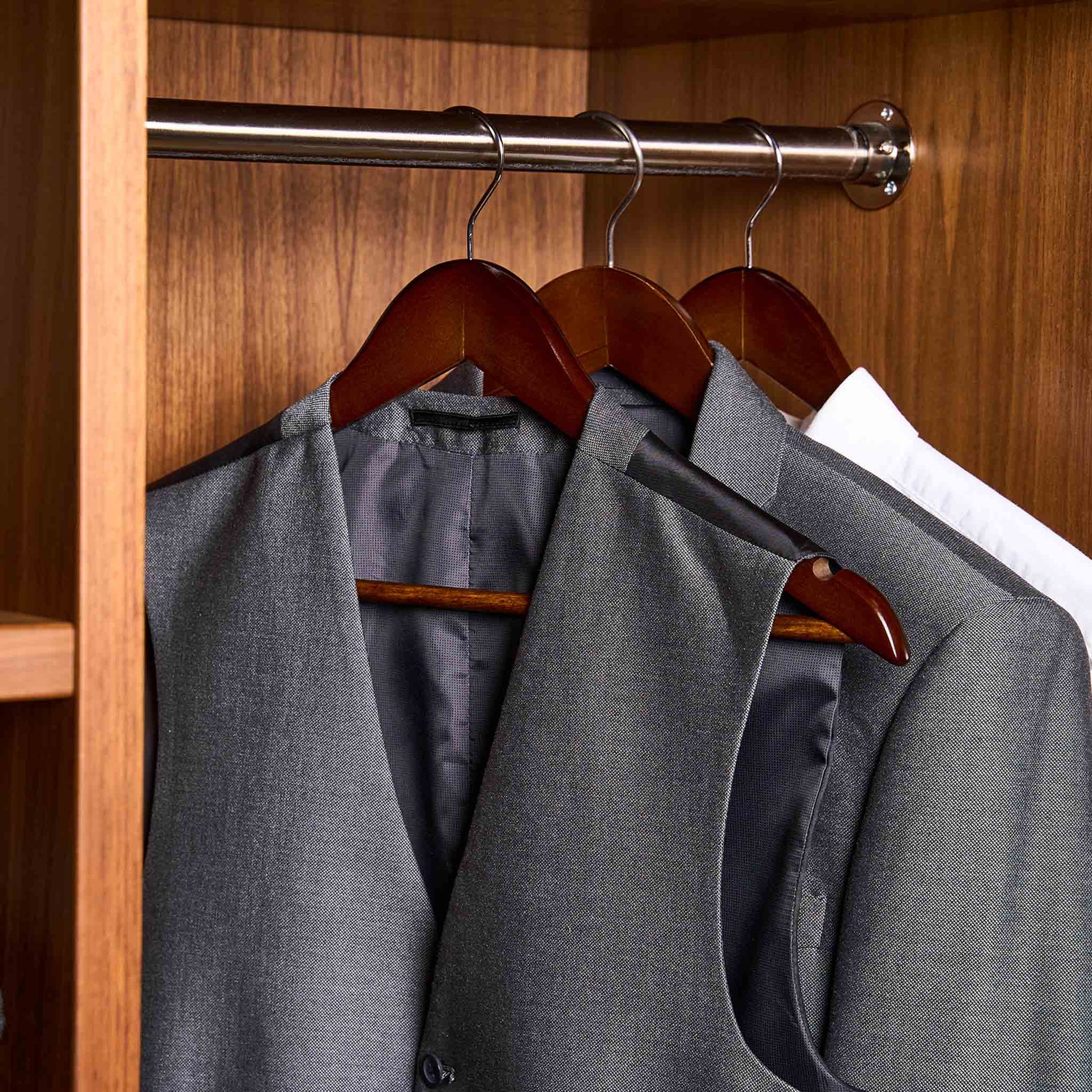 Corby Chelsea dark wood hanger with chrome hook in hotel wardrobe holding guest suit, waistcoat and shirt