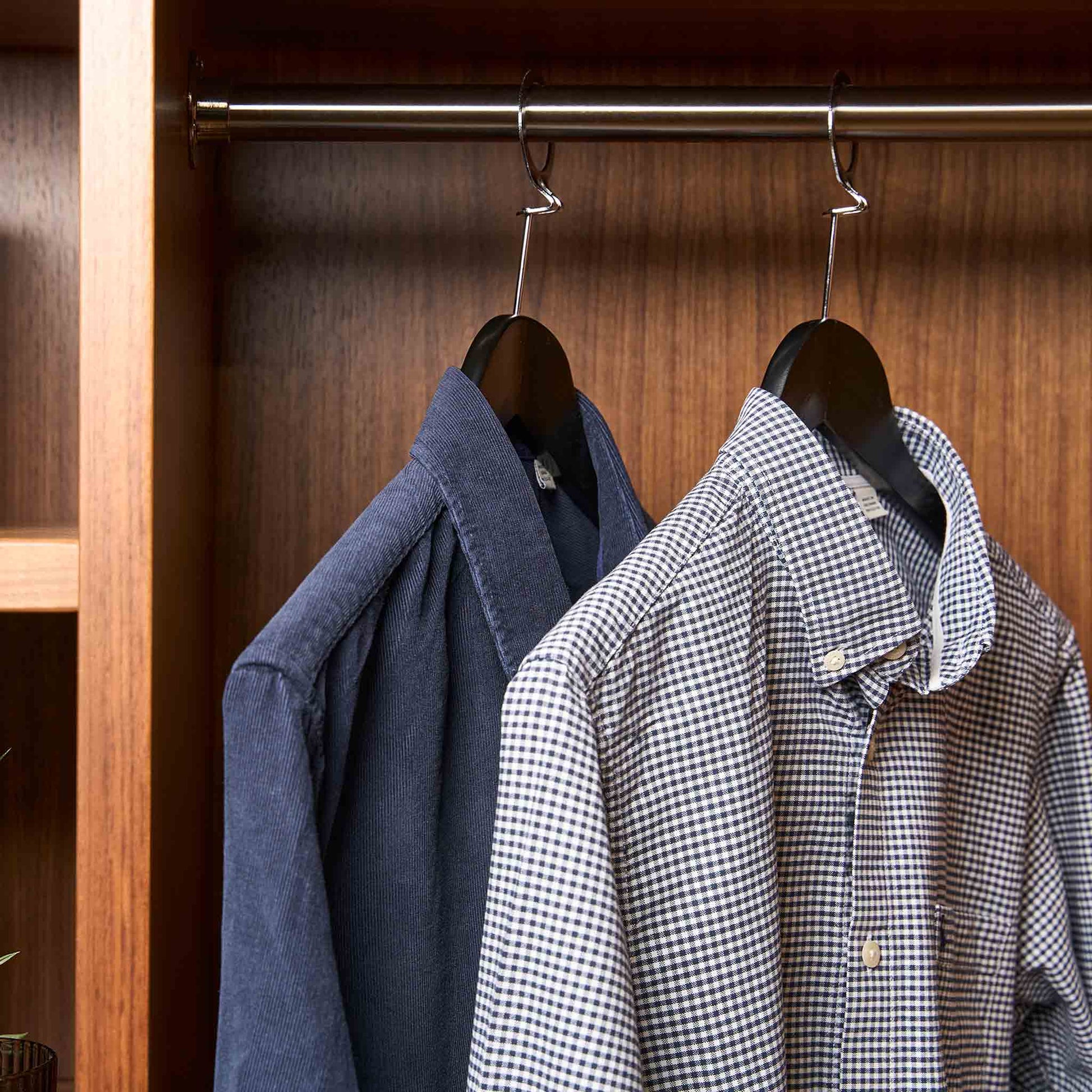 Shirts hanging on matte black Corby Chelsea security hangers with chrome pins in a wardrobe