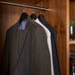 Corby Clifford black wooden suit hangers holding guest clothing in luxury hotel wardrobe with chrome rail