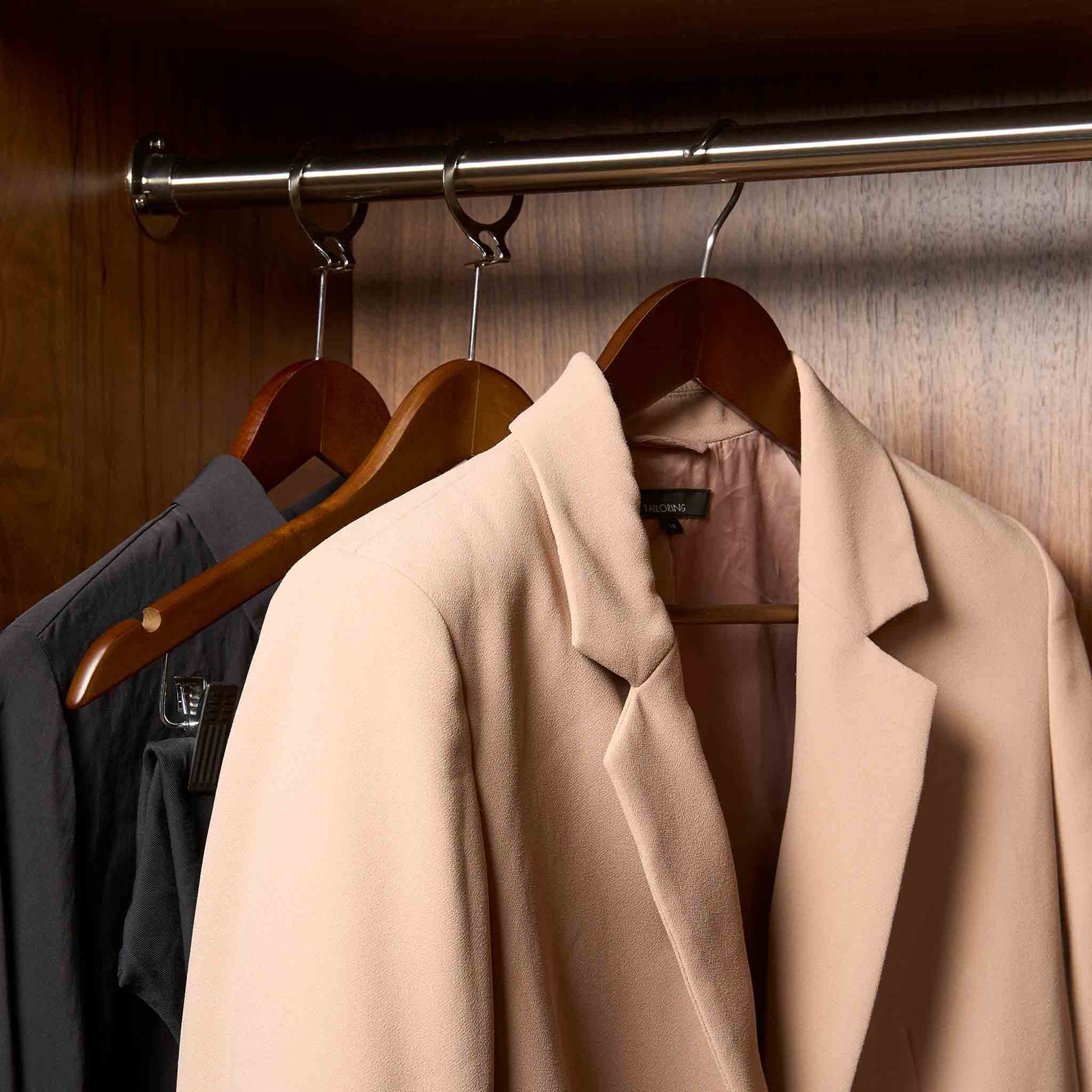 Corby Clifford dark wood hotel hangers with chrome hooks holding guest jacket and clothing in fitted wardrobe