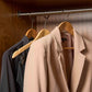 Corby Clifford light wood hotel hangers with chrome hooks holding guest suit and clothing in built-in wardrobe