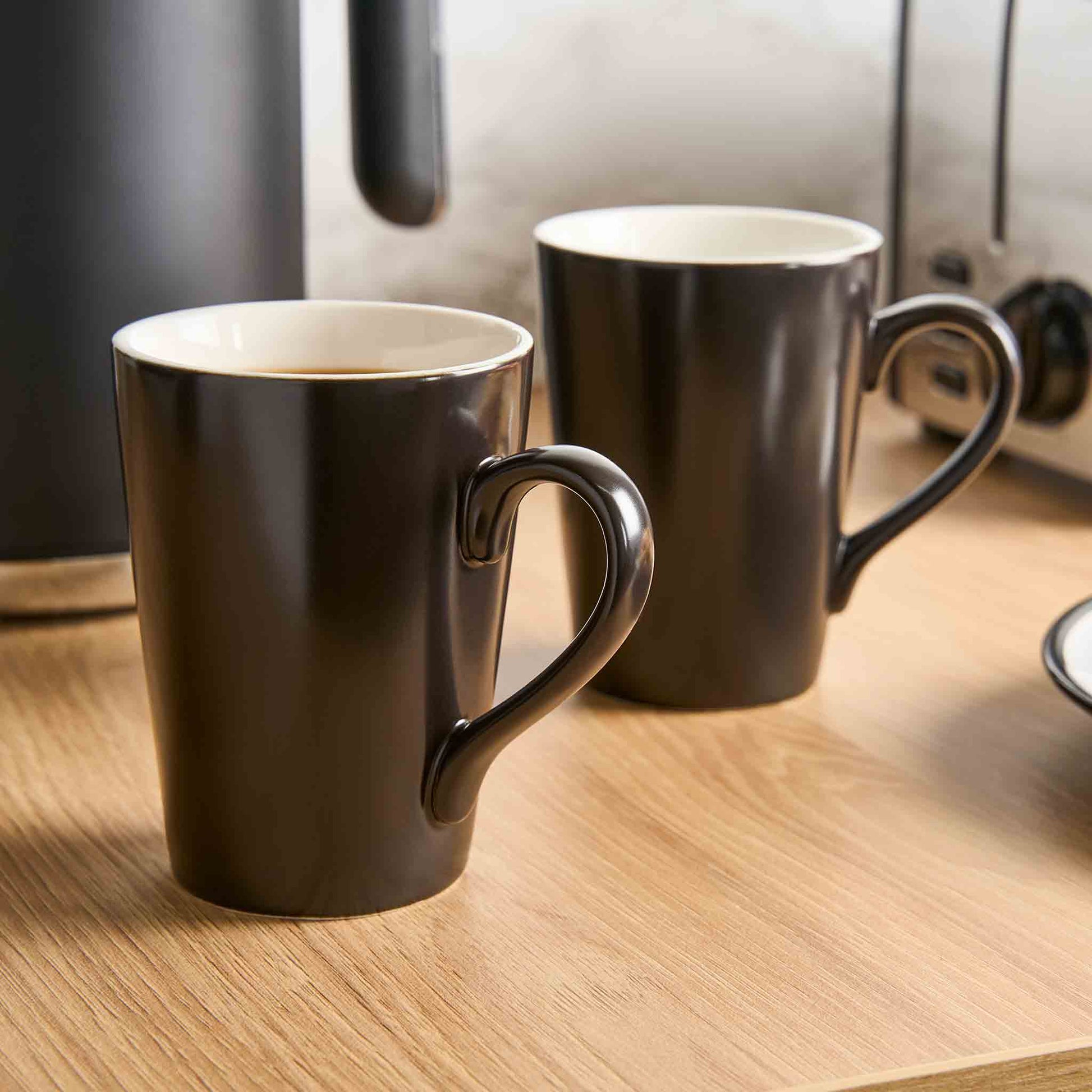 Pair of Corby Fenton black porcelain mugs on hotel room countertop with kettle and toaster, ideal for in-room hospitality service