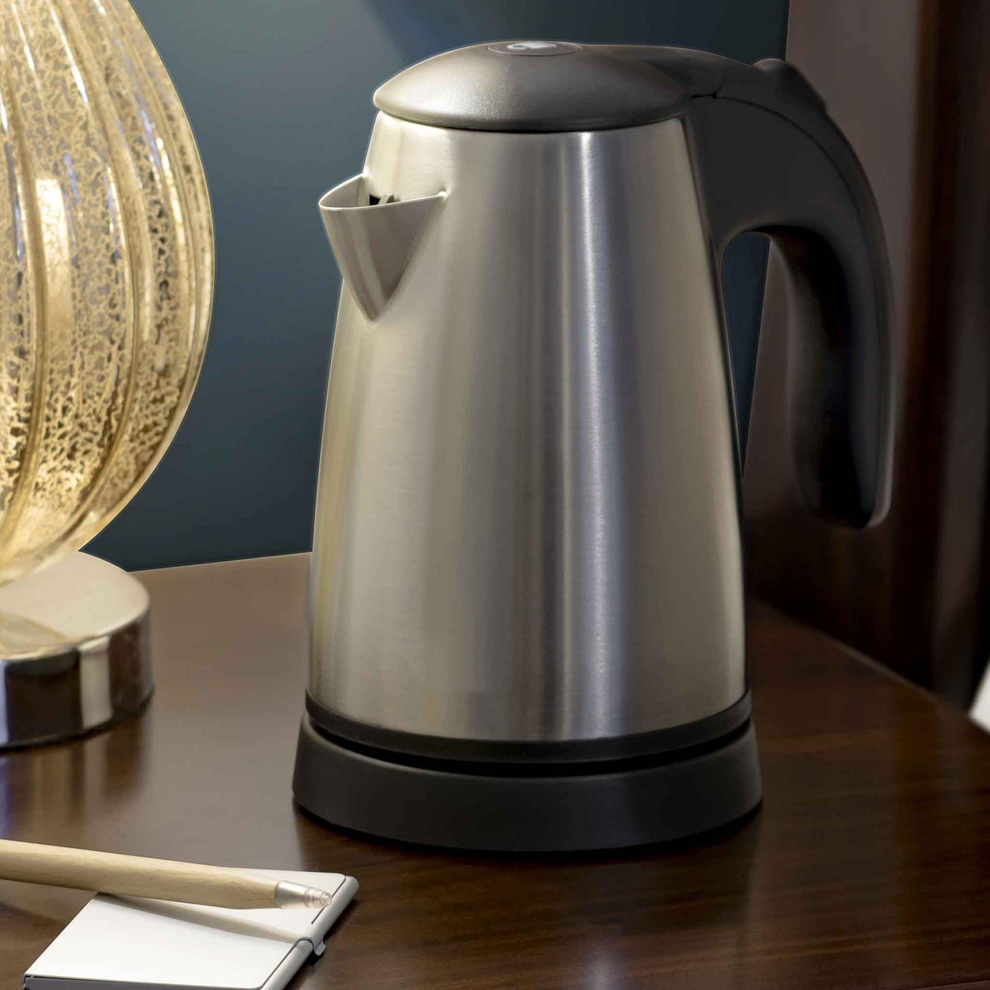 Corby Kensington stainless steel hotel kettle placed on guest room bedside table next to lamp and notepad