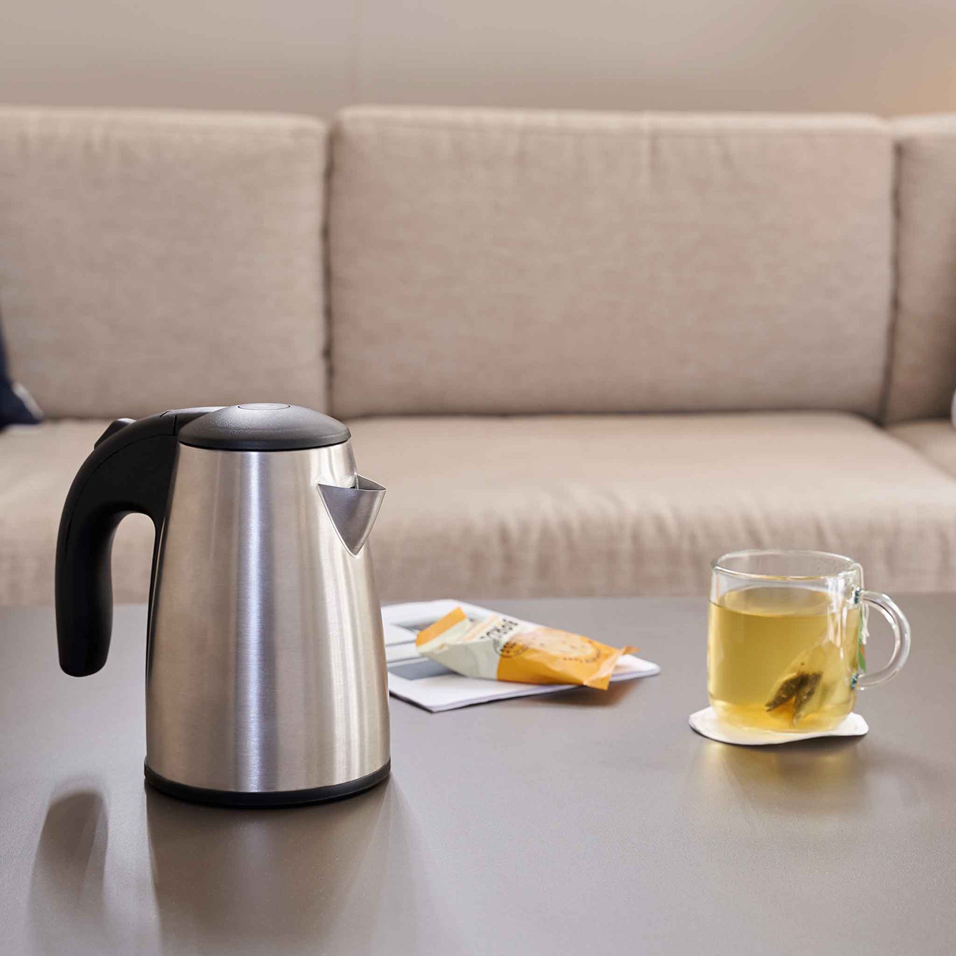 Corby Kensington 0.6L stainless steel hotel kettle on guest room table with tea and snack in hospitality setting