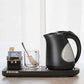 Corby Lancaster 1L black hotel kettle on hospitality tray with glass mug, tea sachets, and spoon, set against a light, minimalist background