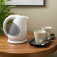 Corby Lancaster 1L white hotel kettle on wooden table with two mugs, spoons, and black hospitality tray in a guest room setting