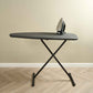 Corby Oxford dark grey ironing board with hotel room iron, set up on wooden floor with neutral wall backdrop
