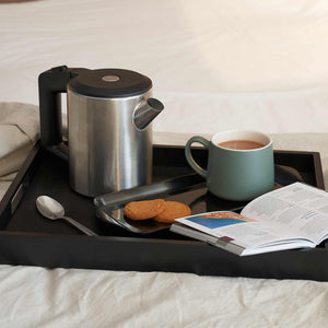 Black wooden butler tray with coffee and biscuits