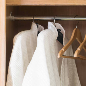 Lifestyle photo of black satin hangers in hotel wardrobe