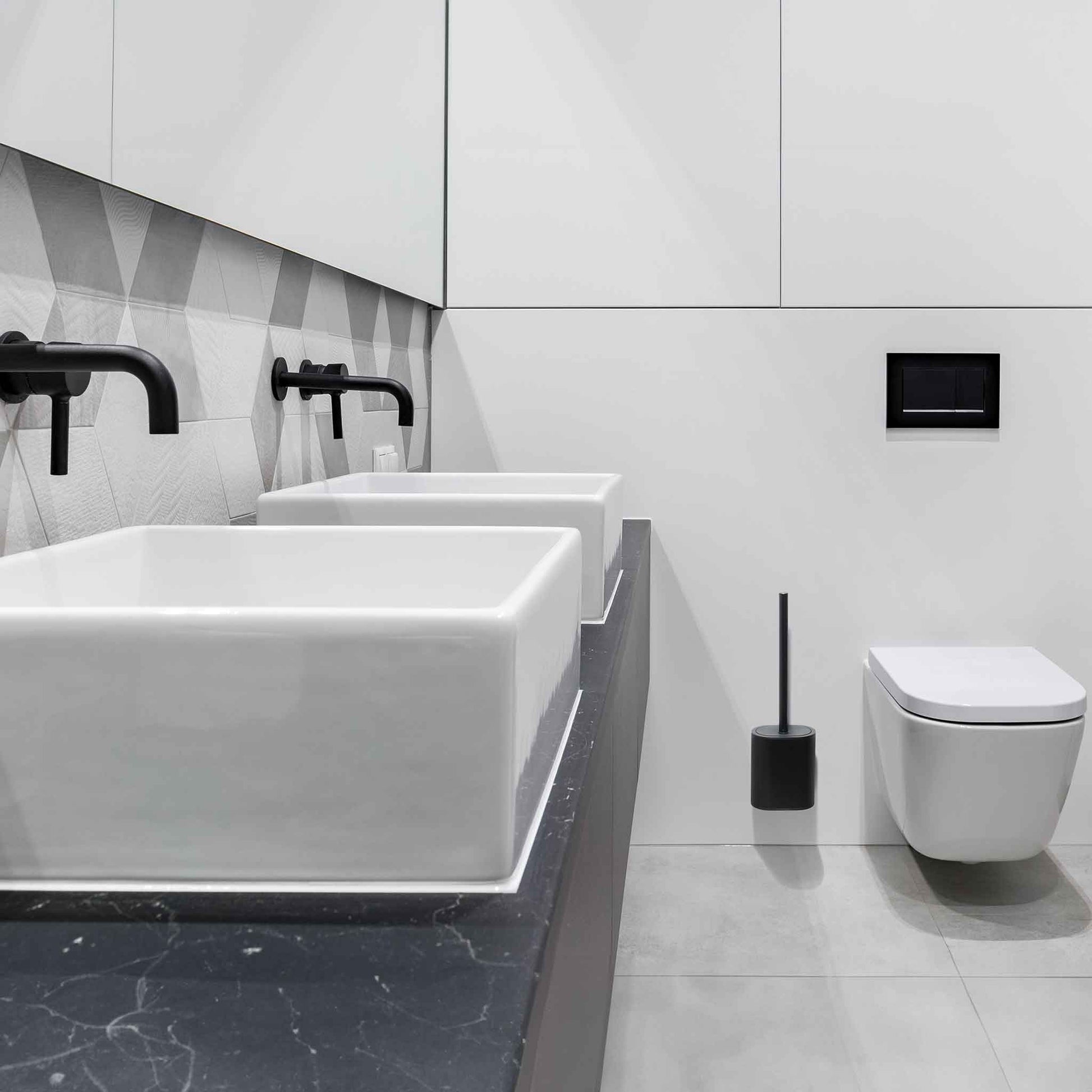 Corby Sana black silicone toilet brush set positioned beside wall-hung toilet in modern hotel bathroom