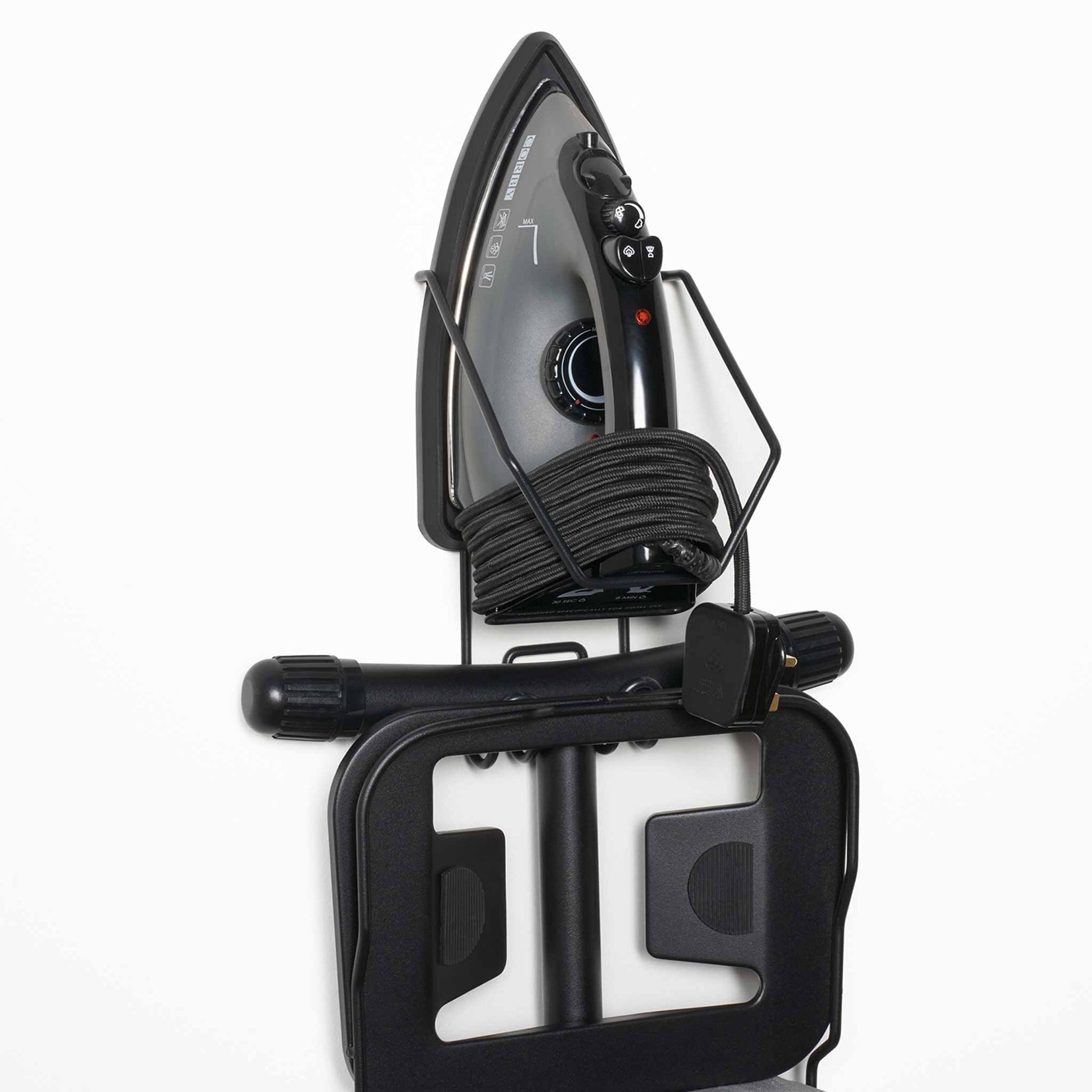 Angled close-up of Corby Sherwood wall-mounted holder storing 1200W steam iron with coiled cord and folded ironing board