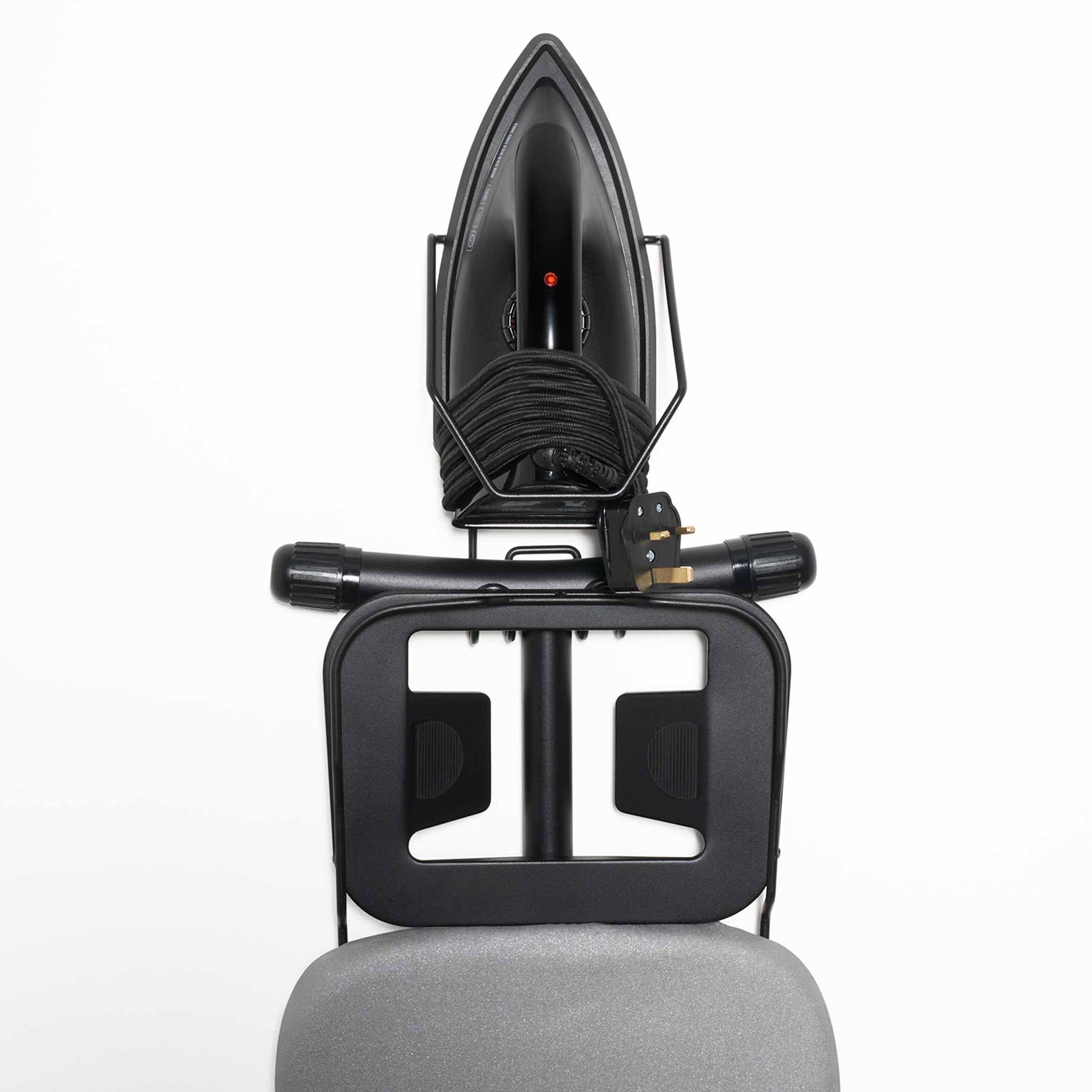 Top-down view of Corby Sherwood ironing board holder securely storing 1200W black dry iron and folded light grey ironing board