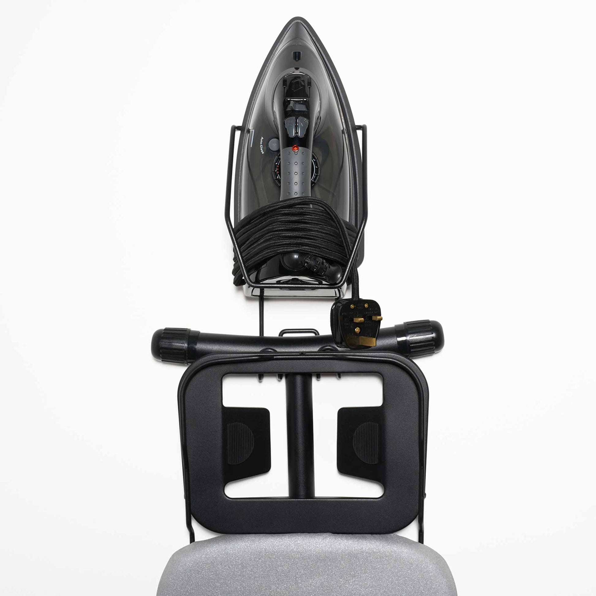 Top-down view of Corby Sherwood 2000W steam iron and compact ironing board stored in wall-mounted holder with neatly wrapped cord
