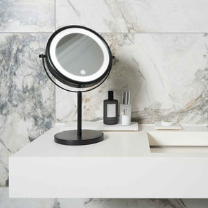 Corby Winchester LED vanity mirror in matt black on luxury hotel bathroom counter with marble wall and guest toiletries
