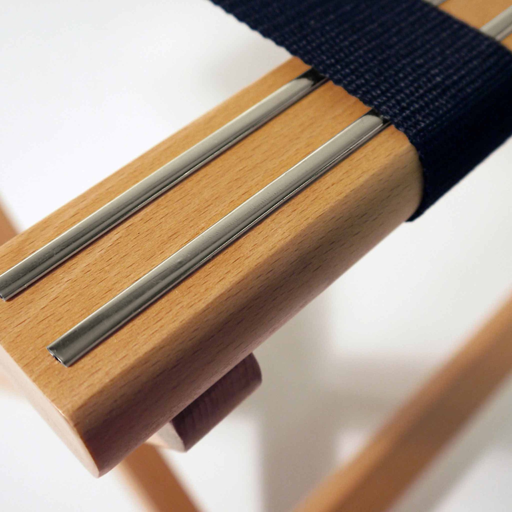 Close-up of Corby York beech wood luggage rack featuring black nylon straps and dual chrome inlays