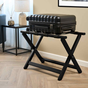 Corby York black wooden luggage rack with black nylon straps, holding a suitcase in a contemporary hotel room setting