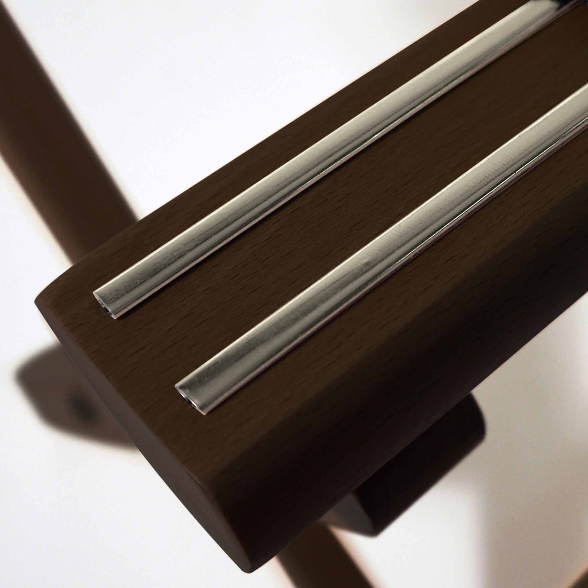 Close-up of Corby York dark wood luggage rack showing chrome inlay detail on top rail