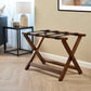 Corby York dark wood luggage rack with black support straps in hotel guest room beside bedside table