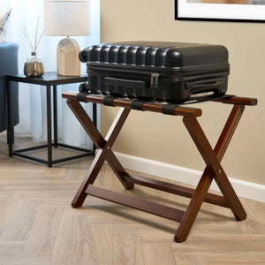 Corby York dark wood folding luggage rack with black suitcase in upscale hotel room setting