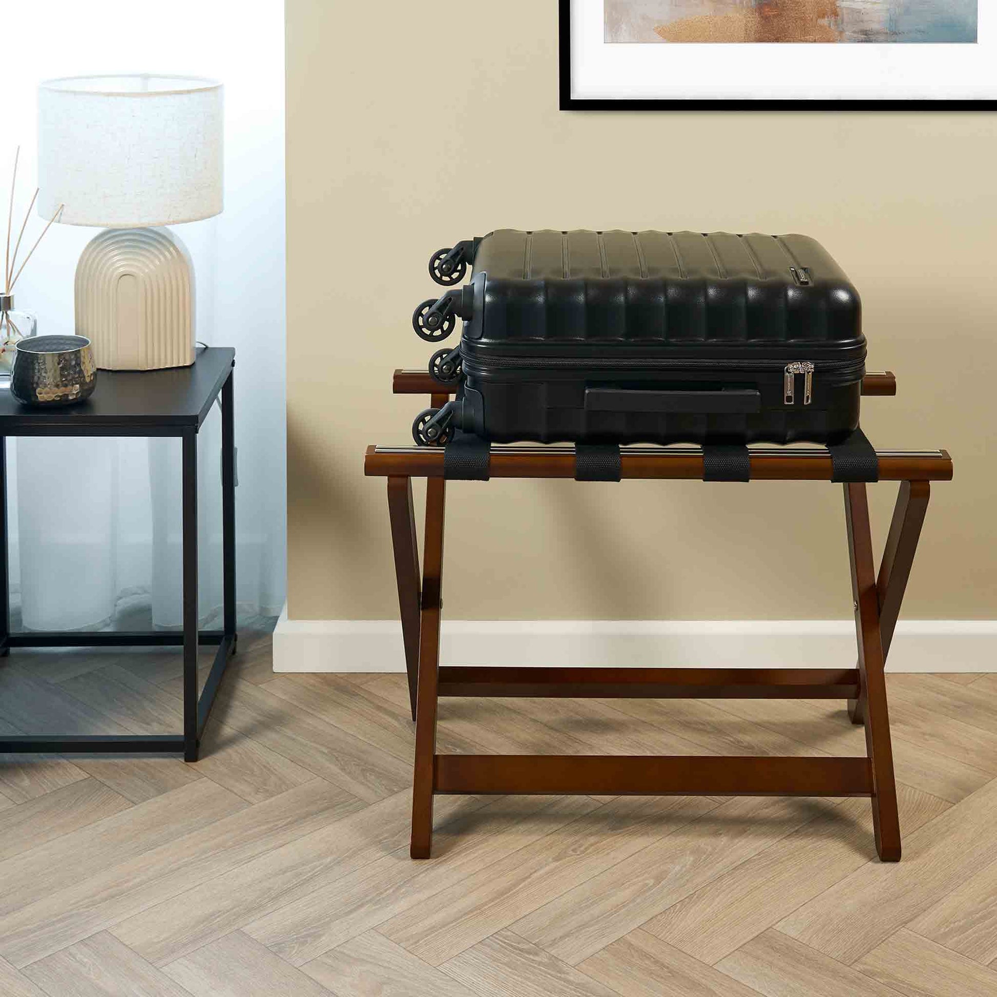 Corby York dark wood luggage rack with black suitcase placed on top in modern hotel guest room
