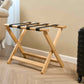 Corby York light wood suitcase stand with foldable X-frame and black nylon straps in modern hotel guest room