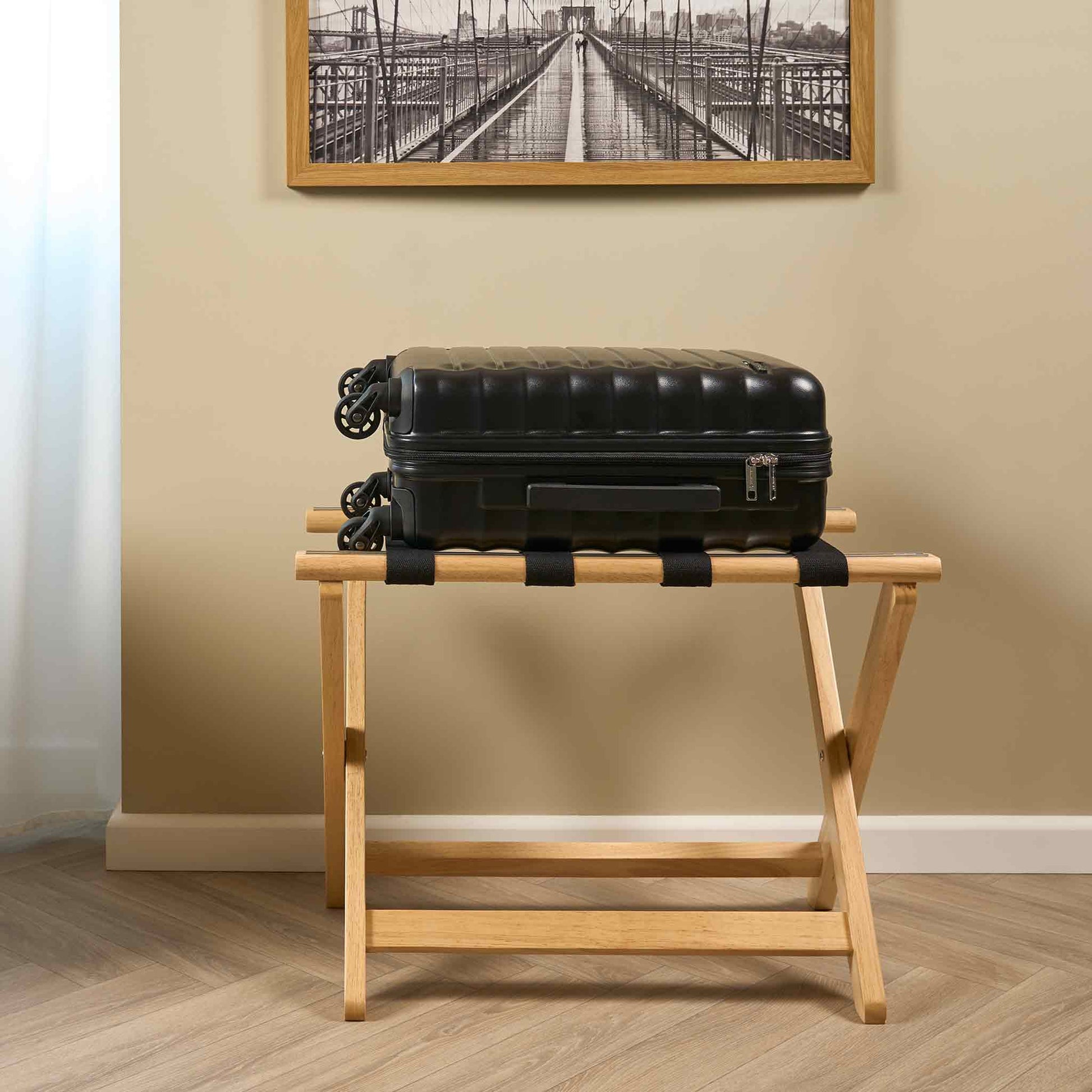 Corby York light wood luggage rack with black nylon straps holding suitcase in hotel guest room