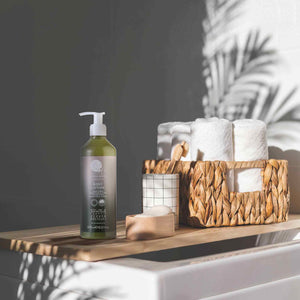 Geneva Green 370ml body lotion pump bottle on hotel bathroom shelf with towels and eco-friendly toiletries