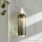Geneva Green 370ml refillable body wash bottle with pump dispenser mounted on hotel bathroom wall, made from 100% recycled plastic