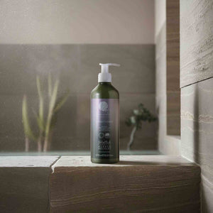 Geneva Green 370ml conditioner in recycled plastic pump bottle placed on hotel bathroom ledge, featuring eco-friendly, refillable design