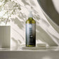 Geneva Green 370ml liquid hand soap in recycled PET bottle displayed in modern bathroom with floral decor and natural light