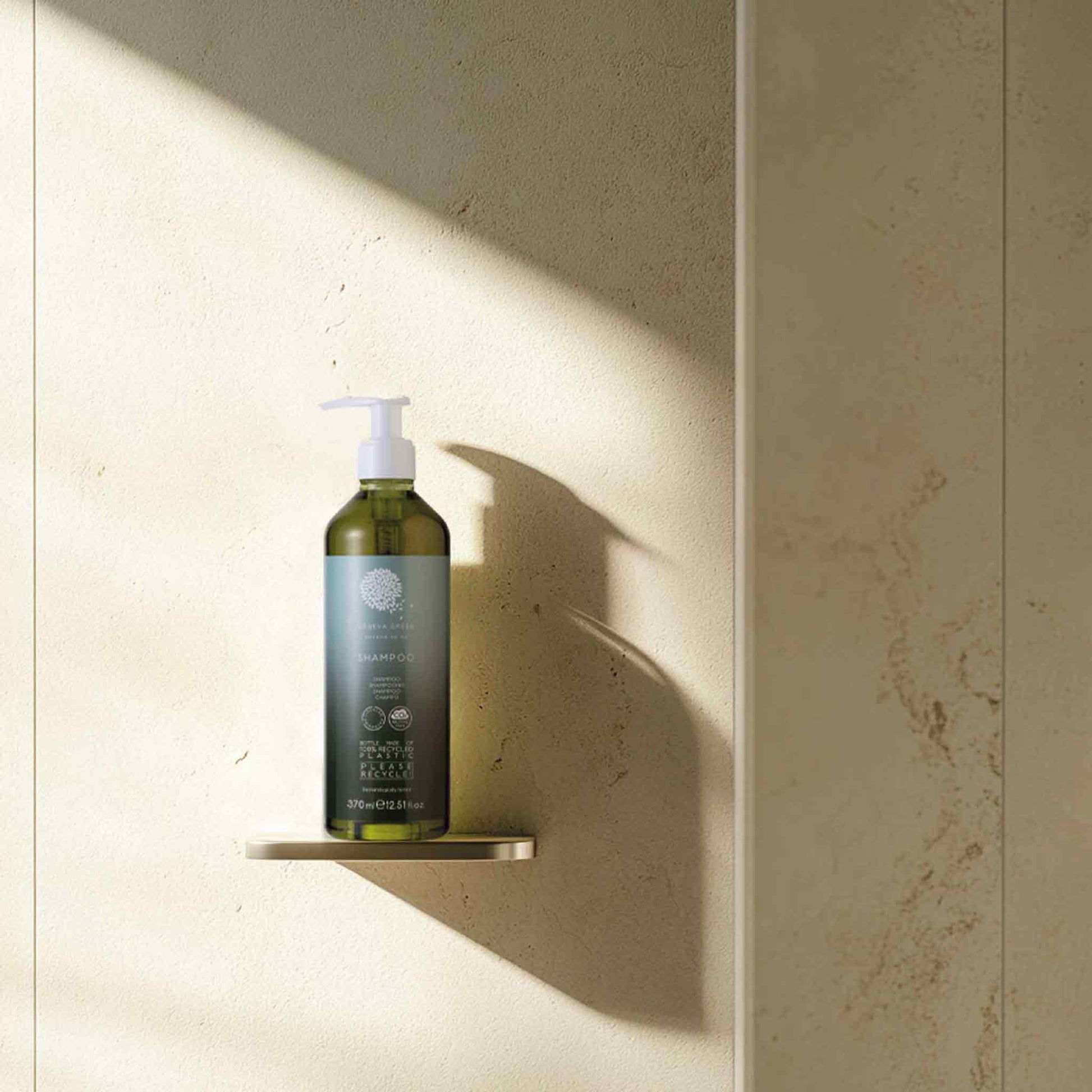 Geneva Green 370ml refillable shampoo bottle with pump dispenser placed on hotel bathroom shelf, made from 100% recycled plastic
