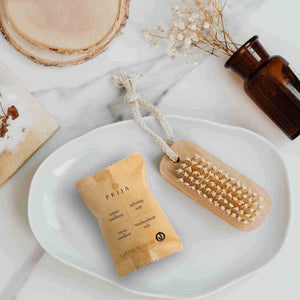 Prija soap bar and brush on a white plate with a marble background