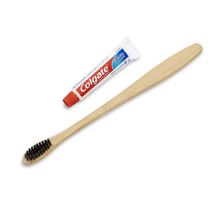 White box amenity contents including bamboo toothbrush and mini colgate toothpaste